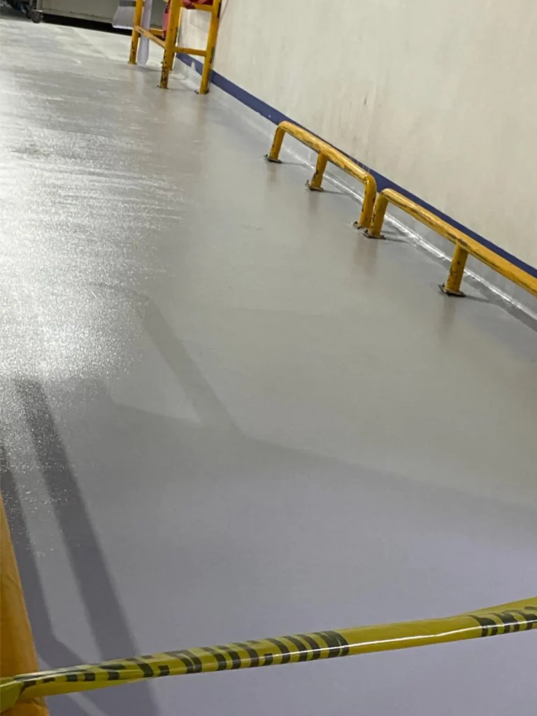 Aplicación de pisos epóxicos y curva sanitaria en pisos industriales con barreras de seguridad para el sector alimentario