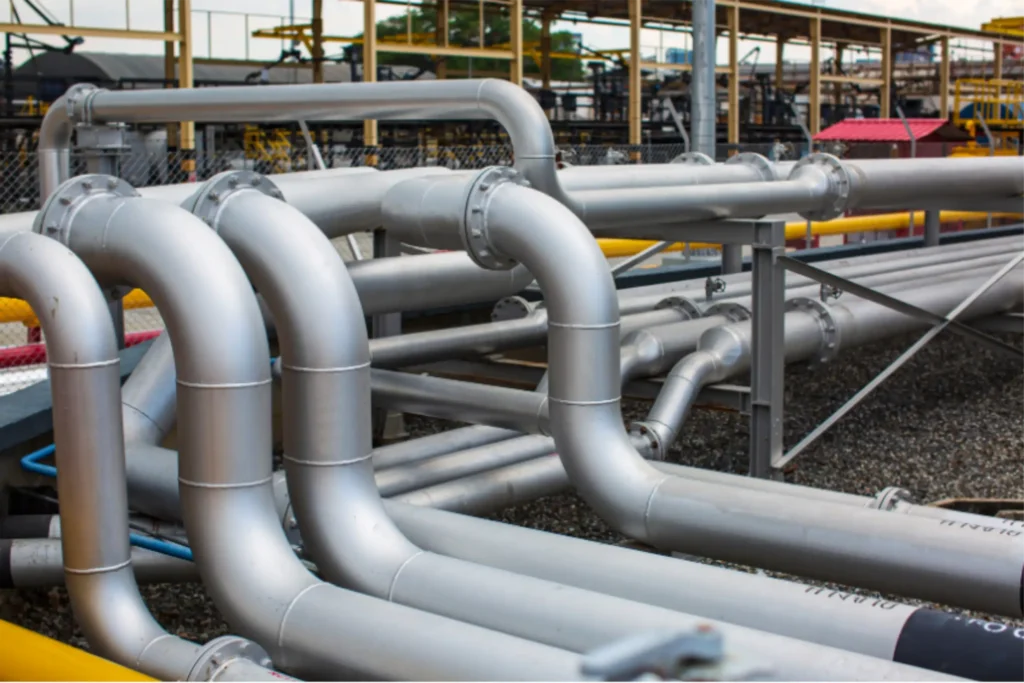Servicios de Instalación de Aislamiento Térmico para Tuberías y Ductos Sitemas de aislamiento térmico en tuberías y ductos en interiores y exteriores con acabado en chaqueta metálica instalados en una planta industrial.