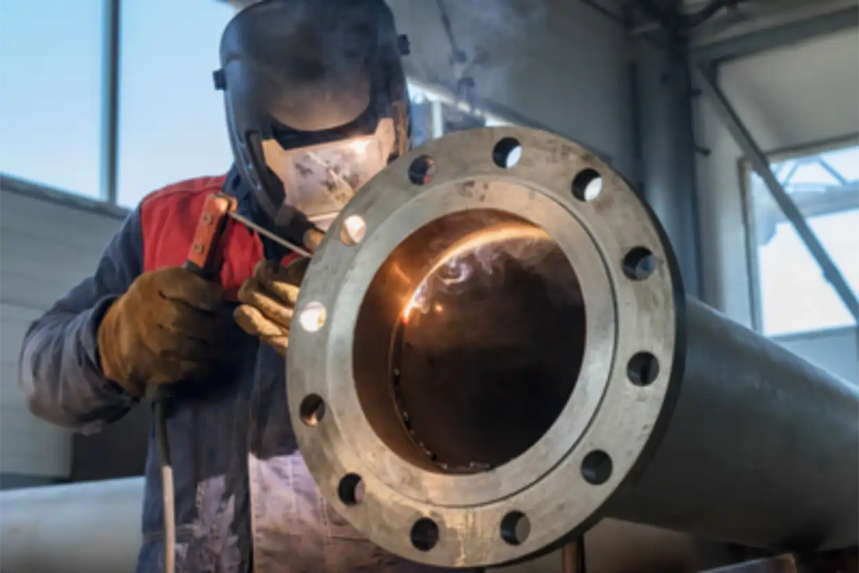Técnico realizando la reparación de tolvas, tubos e infraestructura industrial mediante soldadura TIG o MIG para restaurar la operatividad de sistemas de tuberías y maquinaria en planta.